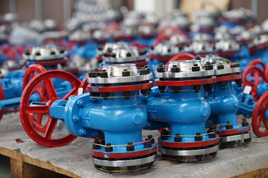Rows of blue and red colored industrial valves manufactured by forged steel gate valve manufacturer Indonesia